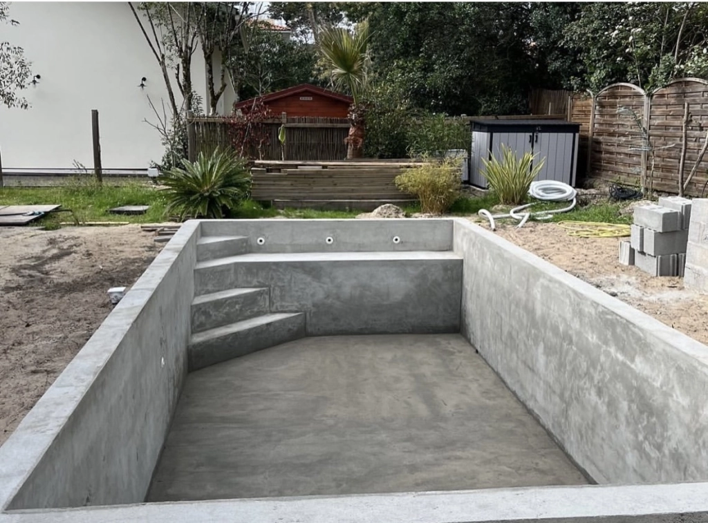 construction de piscine en béton dans le jardin d'une maison